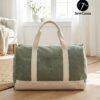 May include: A green duffel bag with cream-coloured accents. The bag has cream-coloured handles and a cream-coloured base. The text "SewLuna" is printed on the side. The bag is on a wooden floor.