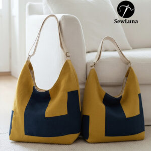 Two finished Aris hobo bags sitting on a white rug against a sofa. The bags feature a modern geometric color-block design in mustard yellow and navy blue with canvas straps. The image displays the Original and Large sizes of this digital sewing pattern.