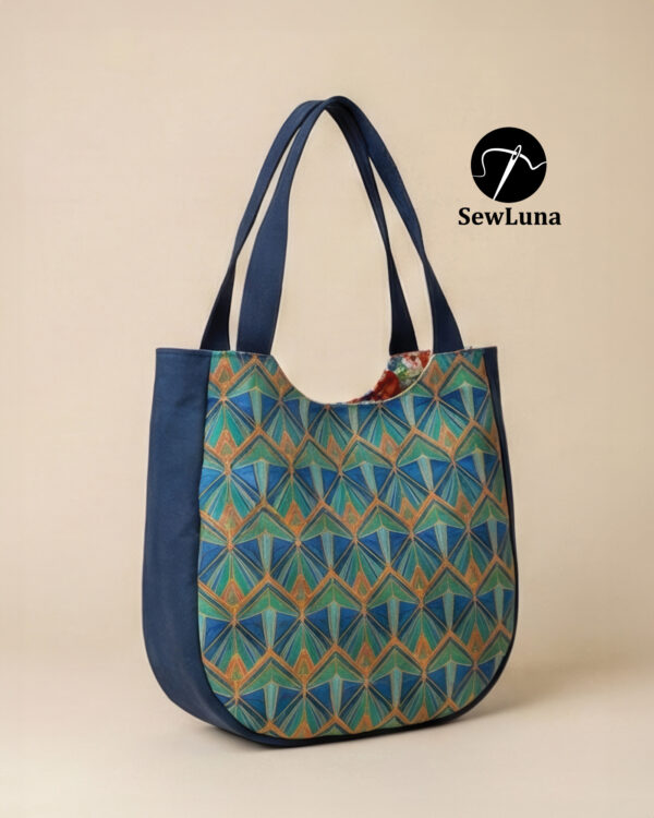 handmade curved tote bags in large and small sizes featuring a blue and teal geometric Art Deco print with navy blue trim and handles, displayed on a light wood floor next to a minimalist wooden chair.